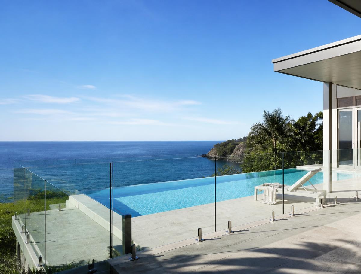 Luxury coastal home with frameless glass pool fence and infinity pool overlooking the ocean